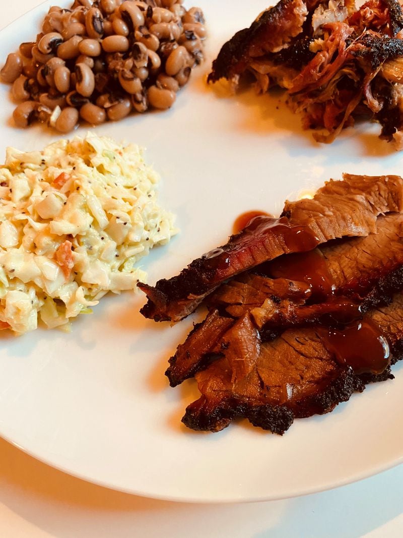 Among the offerings at Community Q are sliced beef brisket, slaw, black-eyed peas with rosemary and bacon, and pulled pork. Bob Townsend for The Atlanta Journal-Constitution