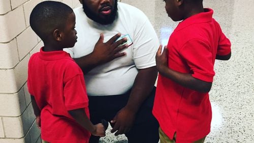 This picture of Markevius Kemp with his two boys last week on the first day at Flat Shoals Elementary School was shared and liked by thousands on social media. (Photo courtesy DeKalb County Public Schools)
