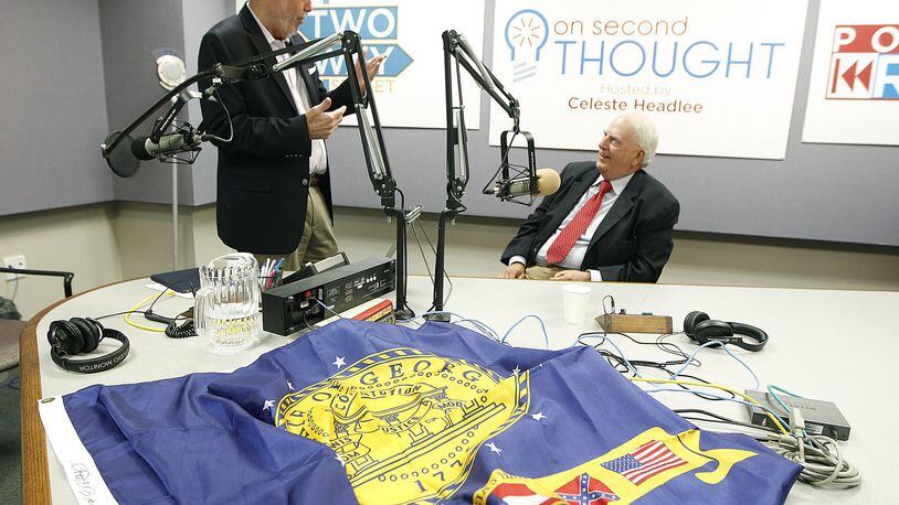 Former Gov. Roy Barnes, right, speaks to radio host Bill Nigut as they prepare for a discussion in 2015 about politics and the Confederate flag. In front of Barnes is the Georgia state flag from 2001 to 2003. Tami Chappell / Special to the AJC