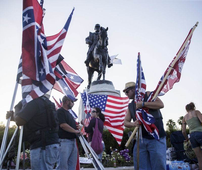 Monument supporters collect their flags before the removal of a Confederate monument to Gen. P.G.T. Beauregard in front of City Park in New Orleans on May 16. (Sophia Germer/The Advocate via AP)