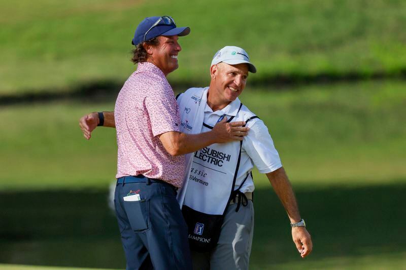 Stephen Ames celebrates with his caddie after making his putt on the 18th green on the 18th hole during the final round of the Mitsubishi Classic senior golf tournament at TPC Sugarloaf, Sunday, April 28, 2024, in Duluth, Ga. (Miguel Martinez/Atlanta Journal-Constitution via AP)