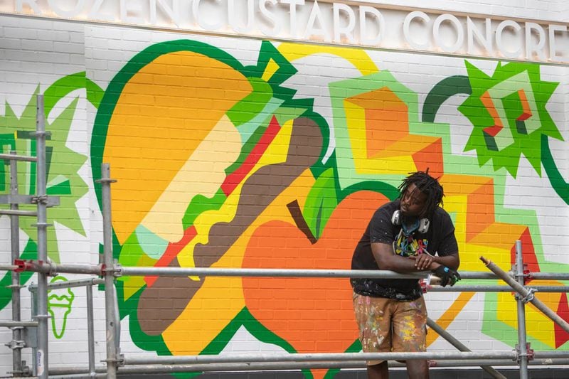 Bongang in front of his midtown mural. (Photo Courtesy of Isadora Pennington)