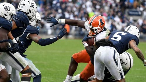 Illinois running back Joshua McCray (0) is tackled by Penn State defensive tackle Derrick Tangelo (54) during overtime of an NCAA college football game in State College, Pa., Saturday, Oct. 23, 2021. Illinois defeated Penn State 20-18 in the ninth overtime. (AP Photo/Barry Reeger)