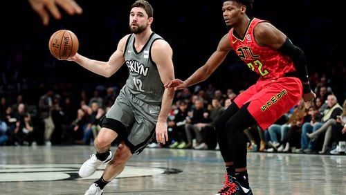 The Hawks Cam Reddish, right, applies a little defense to Brooklyn's Joe Harris. (Photo by Emilee Chinn/Getty Images)