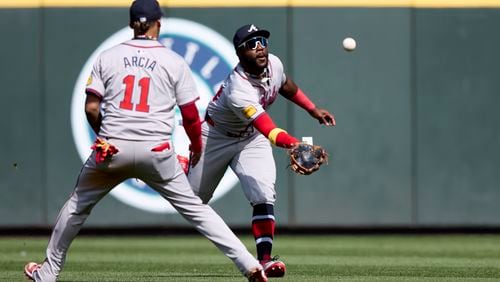 Atlanta Braves center fielder Michael Harris II runs to catch a fly ball for an out on a ball hit by Seattle Mariners' Jorge Polanco with Orlando Arcia left, during the ninth inning of a baseball game, Wednesday, May 1, 2024, in Seattle. The Braves won 5-2. (AP Photo/John Froschauer)