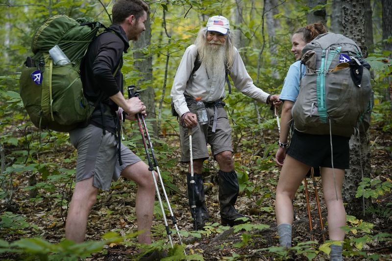 M.J. Eberhart, 83, center, shares trail information with a pair of thru-hikers on the Appalachian Trail in Gorham, New Hampshire. Eberhart is the oldest person to hike the entire 2,193-mile Appalachian Trail. (AP Photo/Robert F. Bukaty)