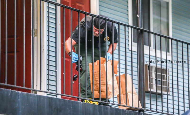 An investigator collects evidence on the second floor of the Efficiency Lodge outside Douglasville on Tuesday morning.