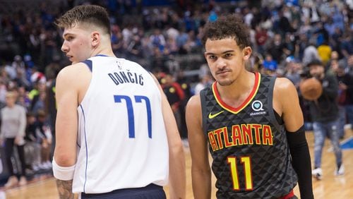 Dallas Mavericks forward Luka Doncic (77) and Hawks guard Trae Young pass in the night following their game Wednesday.