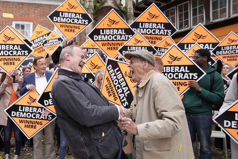 Britain's Liberal Democrat leader Sir Ed Davey, left, is congratulated by a local supporter in Winchester, England, following the results in local government elections, Friday May 3, 2024. (Stefan Rousseau/PA via AP)
