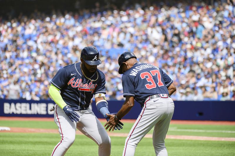 Braves designated hitter Marcell Ozuna (20) and Braves third base coach Ron Washington (37) celebrate after Ozuna hit a two-run home run in the second inning of a baseball game against the Toronto Blue Jays, Saturday, May 13, 2023, in Toronto. (Christopher Katsarov/The Canadian Press via AP)