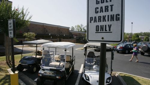 Golf carts park in front of a Kroger in Peachtree City, where residents ride the carts everywhere. Houses will soon fill the remaining land in the city limits, and planners envision an era when the lifestyle trend shifts to renovation instead of building and buying new homes.