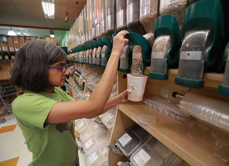 Sonya Shah reuses a plastic container, filling it with organic black-eyed peas in the bulk area at the Sevananda Natural Foods Market in Atlanta. Shah strives to live a zero waste lifestyle. CURTIS COMPTON / CCOMPTON@AJC.COM