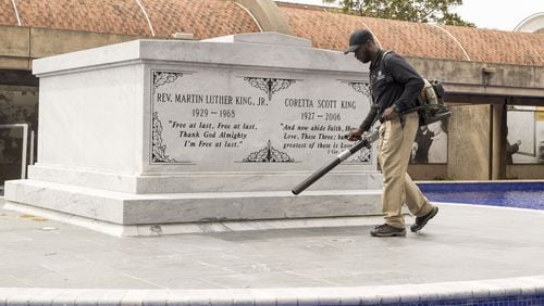 A King Center worker clears debris from the crypt of Martin Luther King Jr. and his wife, Coretta Scott King, at the Martin Luther King Jr. National Historic Park in Atlanta. The King Center and all of Atlanta’s civil right sites are coping with survival in the middle of the coronavirus pandemic ALYSSA POINTER/ALYSSA.POINTER@AJC.COM
