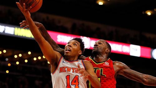 Allonzo Trier (left) of the New York Knicks draws a foul from Dewayne Dedmon of the Hawks.  (Photo by Kevin C. Cox/Getty Images)