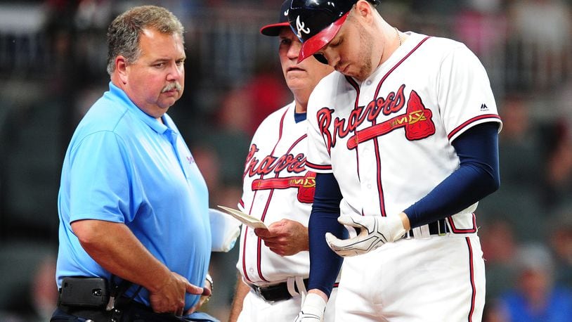 ATLANTA, GA - MAY 17: Freddie Freeman #5 of the Atlanta Braves is removed by Manager Brian Snitker #43 as trainer Jim Lovell watches after being hit by a fifth inning pitch against the Toronto Blue Jays at SunTrust Park on May 17, 2017 in Atlanta, Georgia. (Photo by Scott Cunningham/Getty Images)