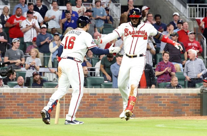 Atlanta Braves left fielder Marcell Ozuna (20) celebrates with teammate Travis d'Arnaud after scoring a home run in the 5th inning in a baseball game at Truist Park on Tuesday, April 12, 2022. Miguel Martinez/miguel.martinezjimenez@ajc.com