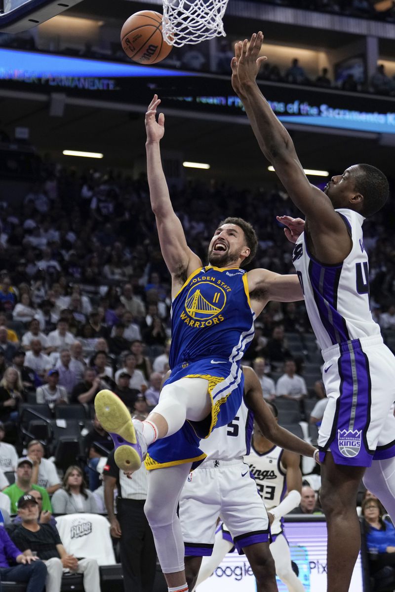 Golden State Warriors guard Klay Thompson (11) shoots next to Sacramento Kings forward Harrison Barnes, right, during the second half of an NBA basketball play-in tournament game Tuesday, April 16, 2024, in Sacramento, Calif. (AP Photo/Godofredo A. Vásquez)