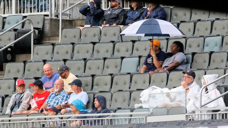Fans wait in the rain before a baseball game between the Atlanta Braves and the San Diego Padres at Trust Park in Atlanta on Monday, July 19, 2021. The game was later postponed due to weather. (Christine Tannous / christine.tannous@ajc.com)