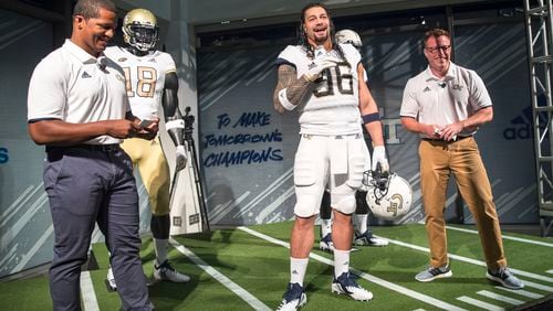 Professional wrestler and former Georgia Tech football player Roman Reigns (center) models the new football uniforms during a reveal party in Atlanta, Friday, August 3, 2018.  (ALYSSA POINTER/ALYSSA.POINTER@AJC.COM)