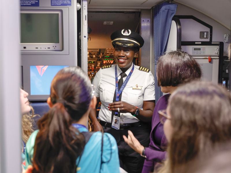 Delta Airlines pilot Captain Aluel Bol greets students as they board the airplane at Hartsfield-Jackson International Airport on Friday, Sept. 22, 2023. The students are a part of Delta’s ‘Women Inspiring our Next Generation’ (WING) program which sponsors an all-female charter flight that carries 100 young women interested in aviation from Atlanta to NASA’s Kennedy Space Center in Florida. (Natrice Miller/ Natrice.miller@ajc.com)