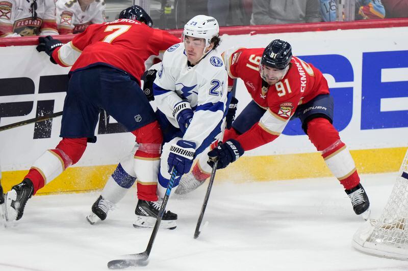 Tampa Bay Lightning center Michael Eyssimont (23) skates with the puck against Florida Panthers defensemen Oliver Ekman-Larsson (91) and Dmitry Kulikov (7) during the second period of Game 1 of the first-round of an NHL Stanley Cup Playoff series, Sunday, April 21, 2024, in Sunrise, Fla. (AP Photo/Wilfredo Lee)