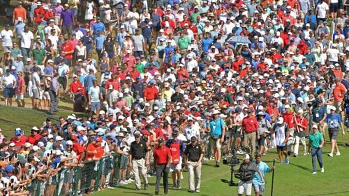 Tiger Woods tends to draw a crowd, as here on the ninth fairway at East Lake Sunday. (HYOSUB SHIN / HSHIN@AJC.COM)