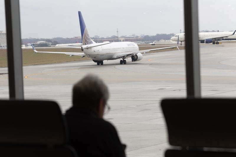   Travelers sit and watch jets depart in the new Concourse T extension at Hartsfield-Jackson Atlanta International Airport Tuesday, December 13, 2022.    (Steve Schaefer/steve.schaefer@ajc.com)
