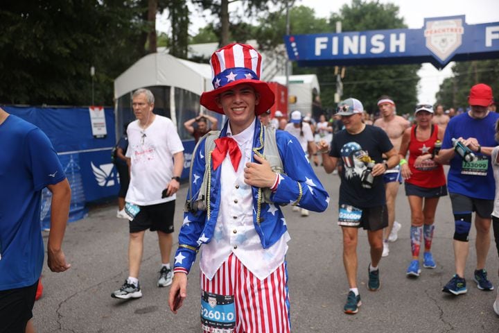 Clark Isaacson’s costume celebrates the Fourth of July at the finish of the 54th running of the Atlanta Journal-Constitution Peachtree Road Race in Atlanta on Tuesday, July 4, 2023.   (Jason Getz / Jason.Getz@ajc.com)