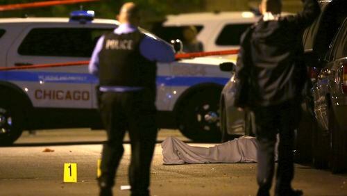 In this May 30, 2016, file photo, police work the scene where a man was fatally shot in the chest in Chicago's Washington Park neighborhood. Trump tweeted Tuesday, Jan. 24, 2017: "If Chicago doesn't fix the horrible 'carnage' going on, 228 shootings in 2017 with 42 killings (up 24% from 2016), I will send in the Feds!" The numbers were slightly different from the latest tally by the Chicago Police Department. As of Tuesday, police said, 234 people have been shot in 2017, including 38 who died. At this point last year, 227 people had been shot, including 33 deaths. (E. Jason Wambsgans/Chicago Tribune via AP, File)