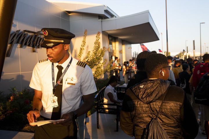 Kyle Greene, a captain with Delta Airlines, organizes participants of Delta’s Dream Flight 2022 event as they line up to pass through security at Hartsfield-Jackson Atlanta International Airport on Friday, July 15, 2022. Around 150 students ranging from 13 to 18 years old will fly from Atlanta to the Duluth Air National Guard Base in Duluth, Minnesota. Greene participated in the program himself when he was a teenager. (Chris Day/Christopher.Day@ajc.com)