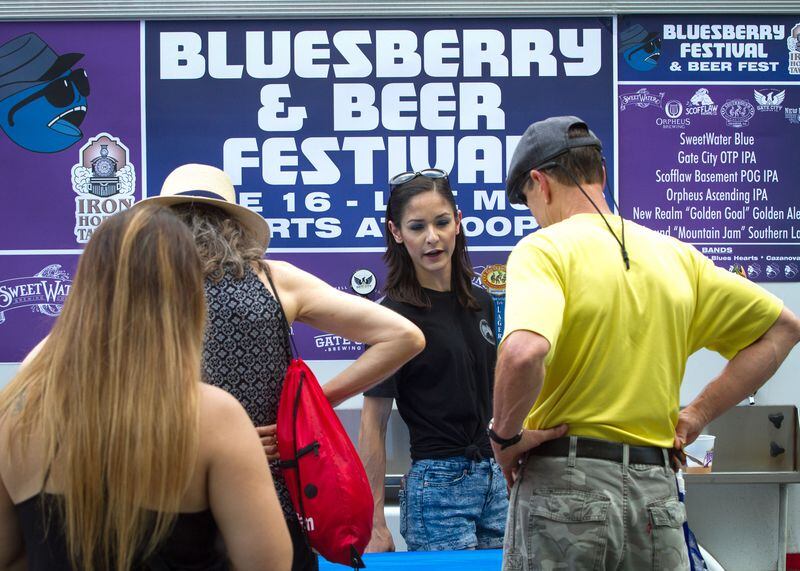 Christan Flores (center) serves beer at the Bluesberry & Beer Festival in Norcross, Ga., on Saturday, June 16, 2018. STEVE SCHAEFER / SPECIAL TO THE AJC