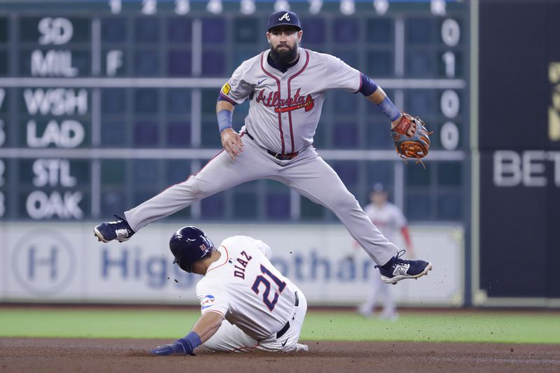 Atlanta Braves second baseman Luis Guillorme, top, jumps over Houston Astros designated hitter Yainer Diaz (21) after throwing to first base as Diaz slides into second base on Guillorme's attempted double play during the fourth inning of a baseball game Wednesday, April 17, 2024, in Houston. Jeremy Pena was safe at first. (AP Photo/Michael Wyke)
