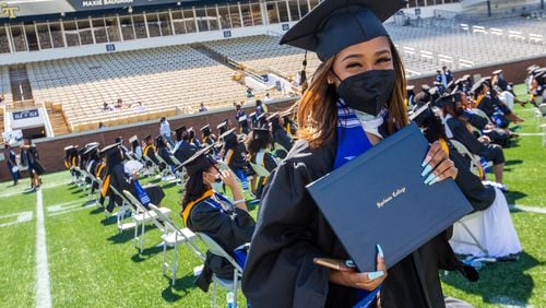 Spelman College holds commencement for the class of 2020 at Bobby Dodd Stadium on Sunday, May 16, 2021.  Students show off their diplomas after walking the stage at graduation.  (Jenni Girtman for The Atlanta Journal-Constitution
