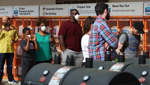 March 29, 2020 Atlanta: Customers wait in line to enter the Home Depot store at Midtown Place while the store limits the number of occupants to maintain six feet of space between shoppers and help prevent the spread of coronavirus on Sunday, March 29, 2020, in Atlanta.   Curtis Compton ccompton@ajc.com