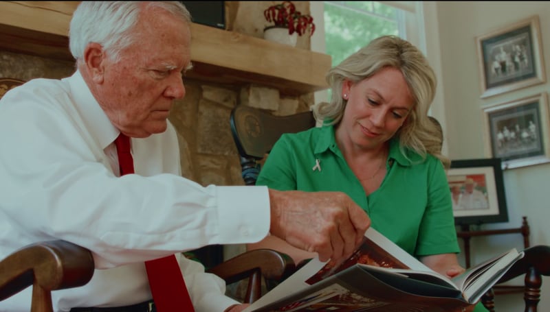 Former Gov. Nathan Deal and Ember Bishop Bentley, who served as special assistant to the first lady, look through images of the late Sandra Deal reading to school children. Photo credit: Wesley Woods Foundation