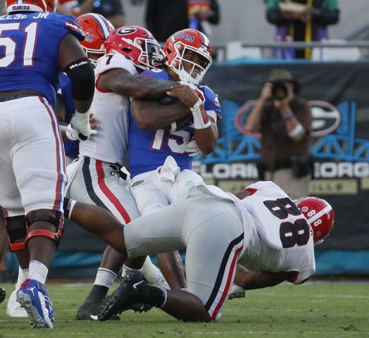 10/30/21 - Jacksonville -  Florida Gators quarterback Anthony Richardson (15) is stopped by Georgia Bulldogs linebacker Quay Walker (7) and  Georgia Bulldogs defensive lineman Jalen Carter (88) during the second half of the annual NCCA  Georgia vs Florida game at TIAA Bank Field in Jacksonville. Georgia won 34-7.  Bob Andres / bandres@ajc.com