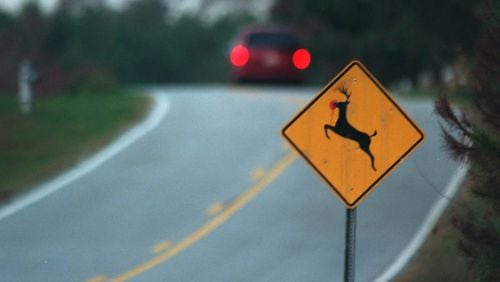 A car drives past a deer crossing sign on Tucker Mill Road. The chances of an auto-deer collision more than double in October, November and December. File / staff