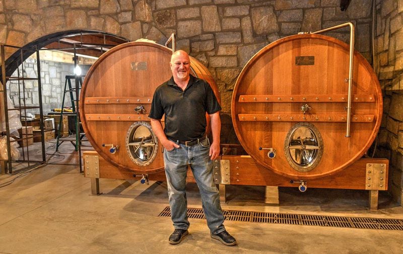 John “JR” Roberts, brewmaster at Bold Monk Brewing Co., stands in front of two oak foeders in the cask room. CONTRIBUTED BY CHRIS HUNT PHOTOGRAPHY