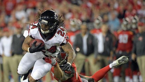 Atlanta Falcons running back Devonta Freeman (24) looks to get around Tampa Bay Buccaneers free safety Chris Conte, right, after a reception during the first half of an NFL football game, Monday, Dec. 18, 2017, in Tampa, Fla. (AP Photo/Phelan M. Ebenhack)