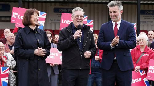 Britain's Labour Party leader Sir Keir Starmer, center, and shadow chancellor Rachel Reeves, celebrate with David Skaith at Northallerton Town Football Club, North Yorkshire, after winning the York and North Yorkshire mayoral election, Friday May 3, 2024. (Owen Humphreys/PA via AP)