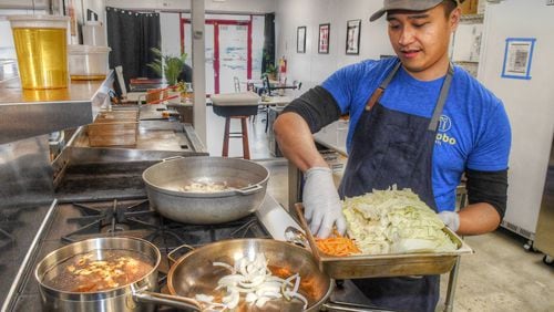 Mike Pimentel, owner of Adobo ATL Filipino pop-up, sautees onions and other ingredients for pancit at his new commissary kitchen. HIs modern interpretations of Filipino cuisine reflect his Filipino roots and his American upbringing. (Chris Hunt for The Atlanta Journal-Constitution)