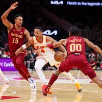 Atlanta Hawks guard Kobe Bufkin (4) drives against Cleveland Cavaliers guard Zhaire Smith (19) and guard Sharife Cooper (00) during the second half of a NBA preseason game at State Farm Arena, Tuesday, October 10, 2023, in Atlanta. The Hawks won 108-107. (Jason Getz / Jason.Getz@ajc.com)