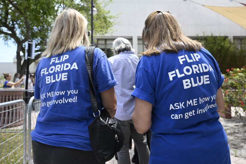 Supporters wear shirts with the message "Flip Florida Blue" while waiting in line to see President Joe Biden speak during a reproductive freedom campaign event at Hillsborough Community College, Tuesday, April 23, 2024, in Tampa, Fla. (AP Photo/Phelan M. Ebenhack)