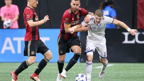 June 30, 2018 Atlanta: Atlanta United midfielder Jeff Larentowicz (from left) and Leandro Gonzalez Pirez take it away from Orlando City forward Chris Mueller during the second half in a MLS soccer match on Saturday, June 30, 2018, in Atlanta.     Curtis Compton/ccompton@ajc.com