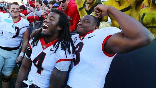 Georgia running back James Cook (left) and tailback Zamir White celebrate a 45-0 victory over Georgia Tech in a NCAA college football game on Saturday, Nov. 27, 2021, in Atlanta.   “Curtis Compton / Curtis.Compton@ajc.com”`