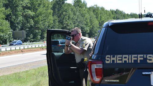 Forsyth County Sheriff’s Department Corporal Brian Chatham utilizes a laser speed gun to enforce the speed limit on the southbound lanes of Ga. route 400 near exit 16. Marty Farrell for the AJC