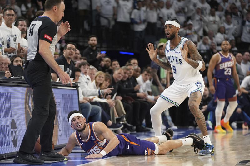 Phoenix Suns guard Devin Booker, center, lays on the ground after a Suns turnover during the second half of Game 2 of an NBA basketball first-round playoff series against the Minnesota Timberwolves, Tuesday, April 23, 2024, in Minneapolis. (AP Photo/Abbie Parr)