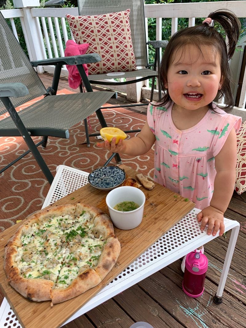 Calliope Hsu gives her clam pizza a squeeze of lemon.