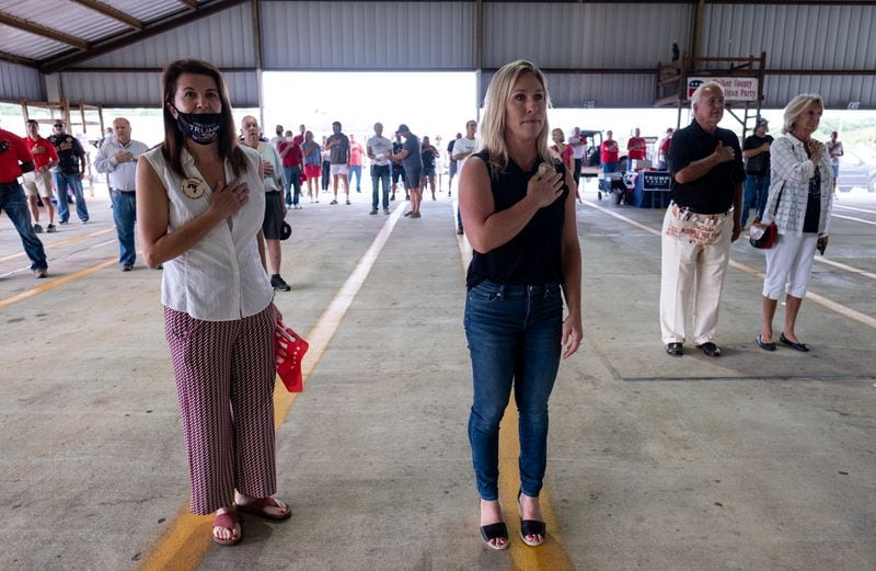 Marjorie Taylor Greene, right, recites the Pledge of Allegiance at a political rally at the Rome fairgrounds Saturday morning, Aug. 29. (Ben Gray for the Atlanta Journal-Constitution)
