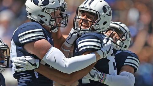 BYU wide receiver Neil Pau'u, center, celebrates his touchdown with teammates Matt Bushman, left, and Inoke Lotulelei, right, in the first half of an NCAA college football game against Portland State, Saturday, Aug. 26, 2017, in Provo, Utah. (AP Photo/Rick Bowmer)